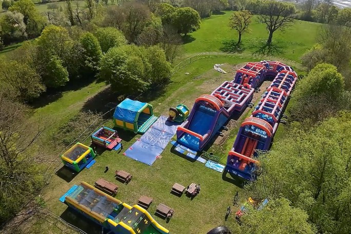 Aerial view of inflatable obstacle courses and slides in a park.