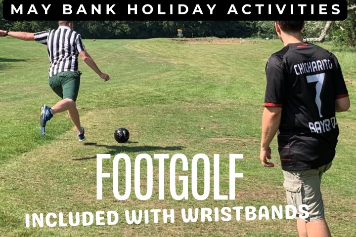 Two people playing footgolf, one kicking a ball, grassy field background.